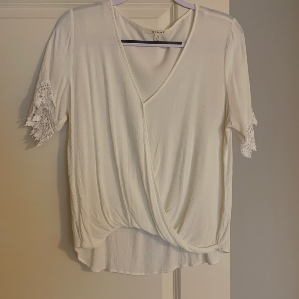 White crossover shirt with lace trim on arms. Size medium. Excellent condition.